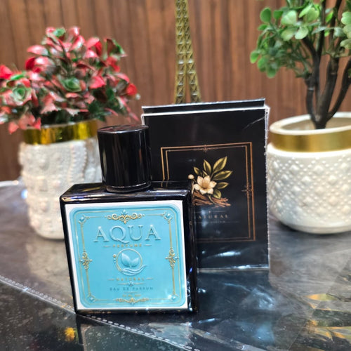 Perfume bottle labeled 'Aqua' on a reflective surface with decorative items in the background.