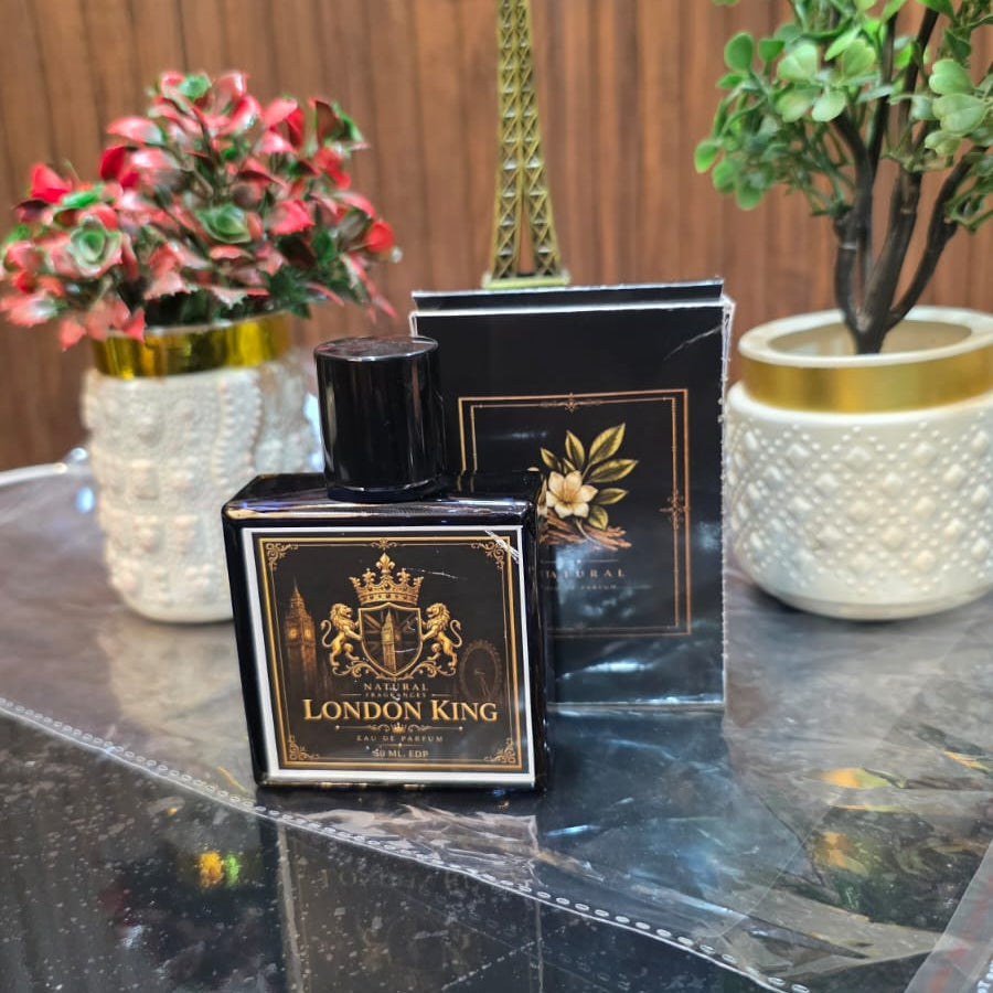 Perfume bottle labeled 'London King' on a reflective surface with decorative elements.